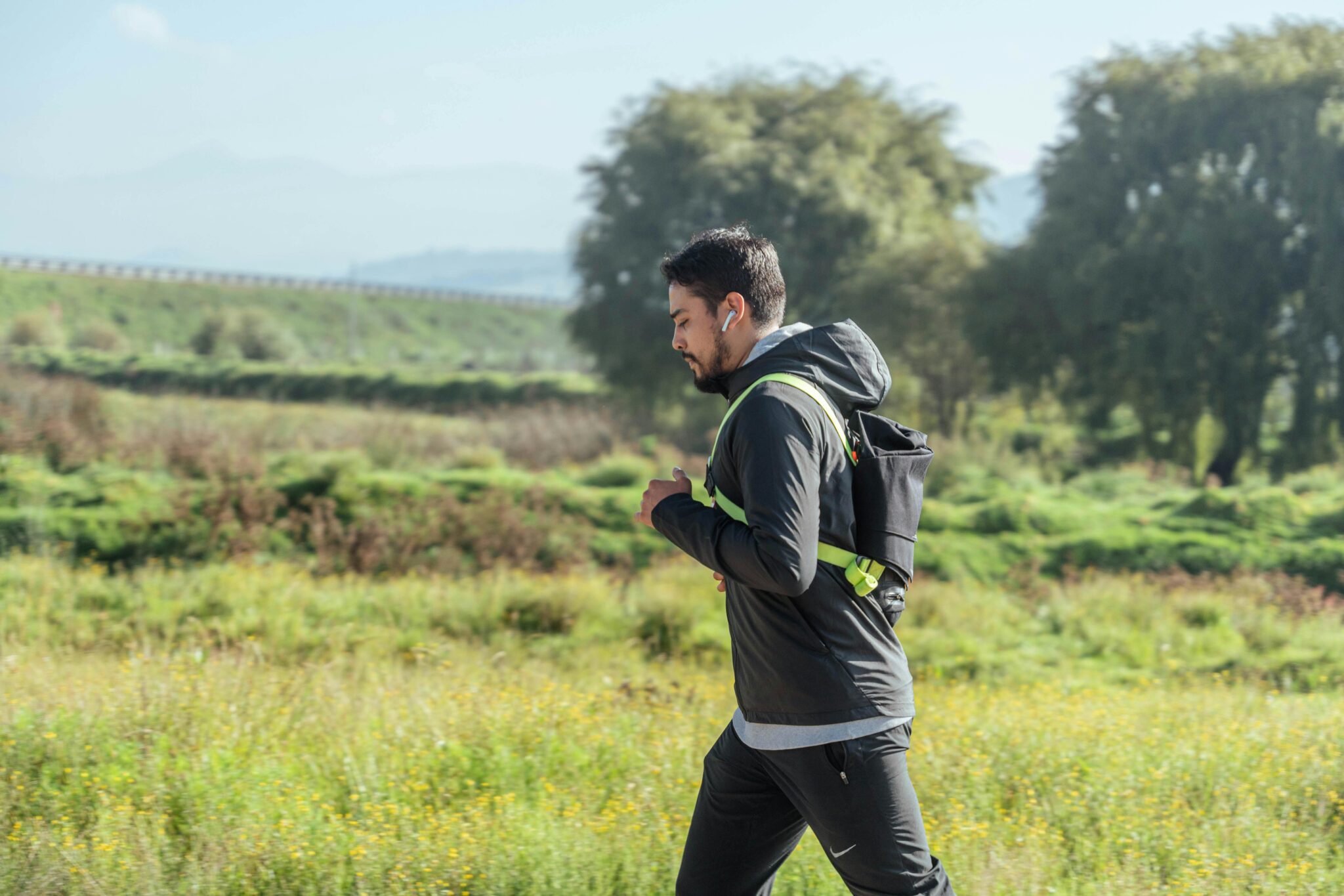 A man using AirPods while jogging outdoors